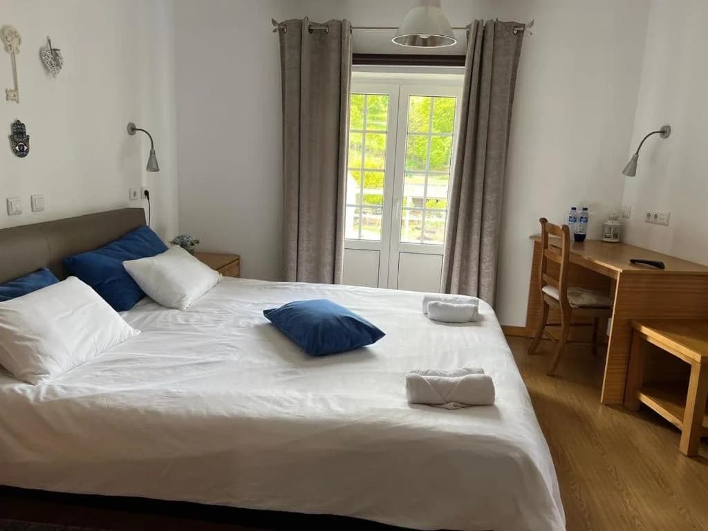Quarto Topázio com cama de casal, varanda com luz natural e secretária